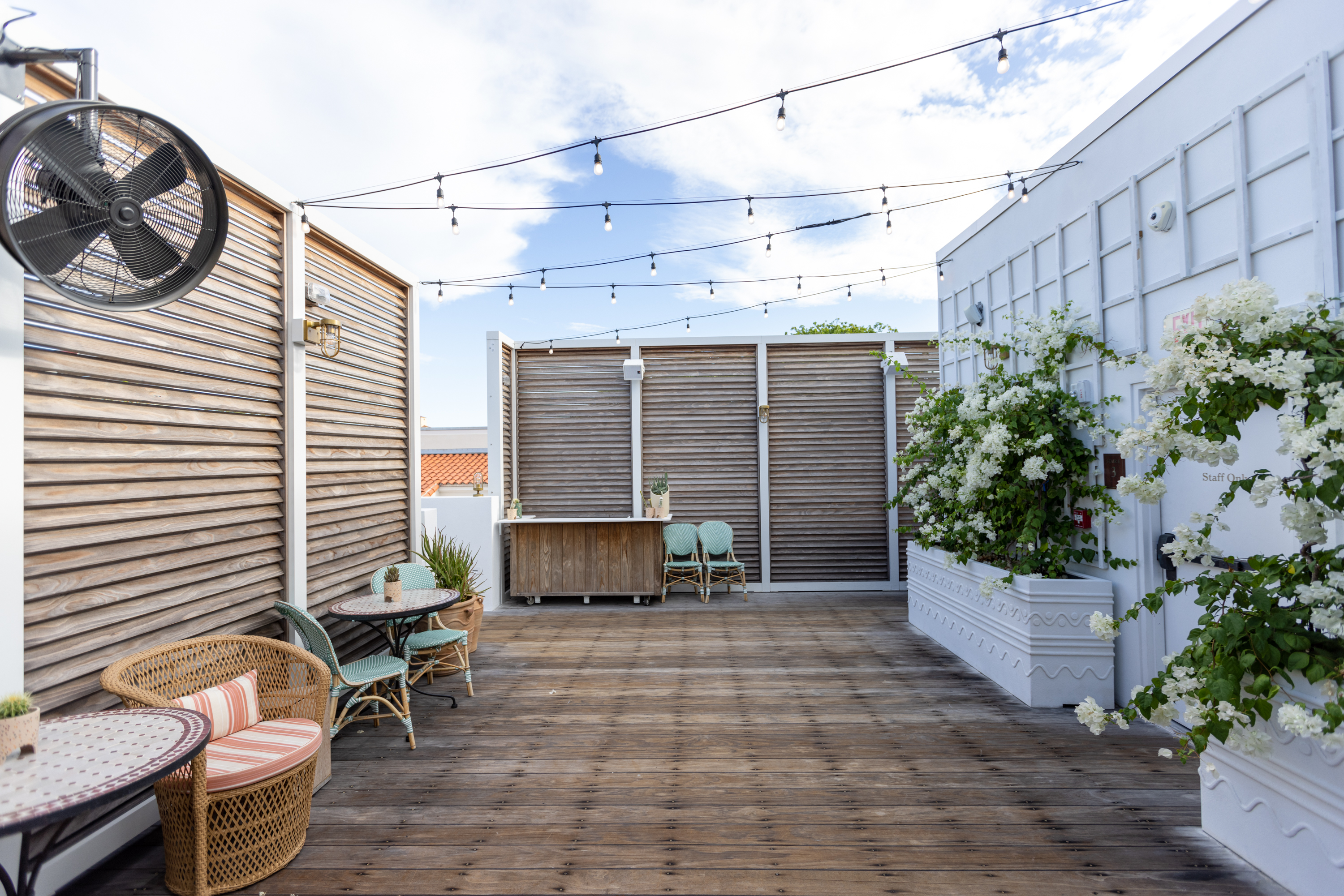 Rooftop deck with wood slat screens, string lights, and bar — Esme Hotel, Miami Beach FL