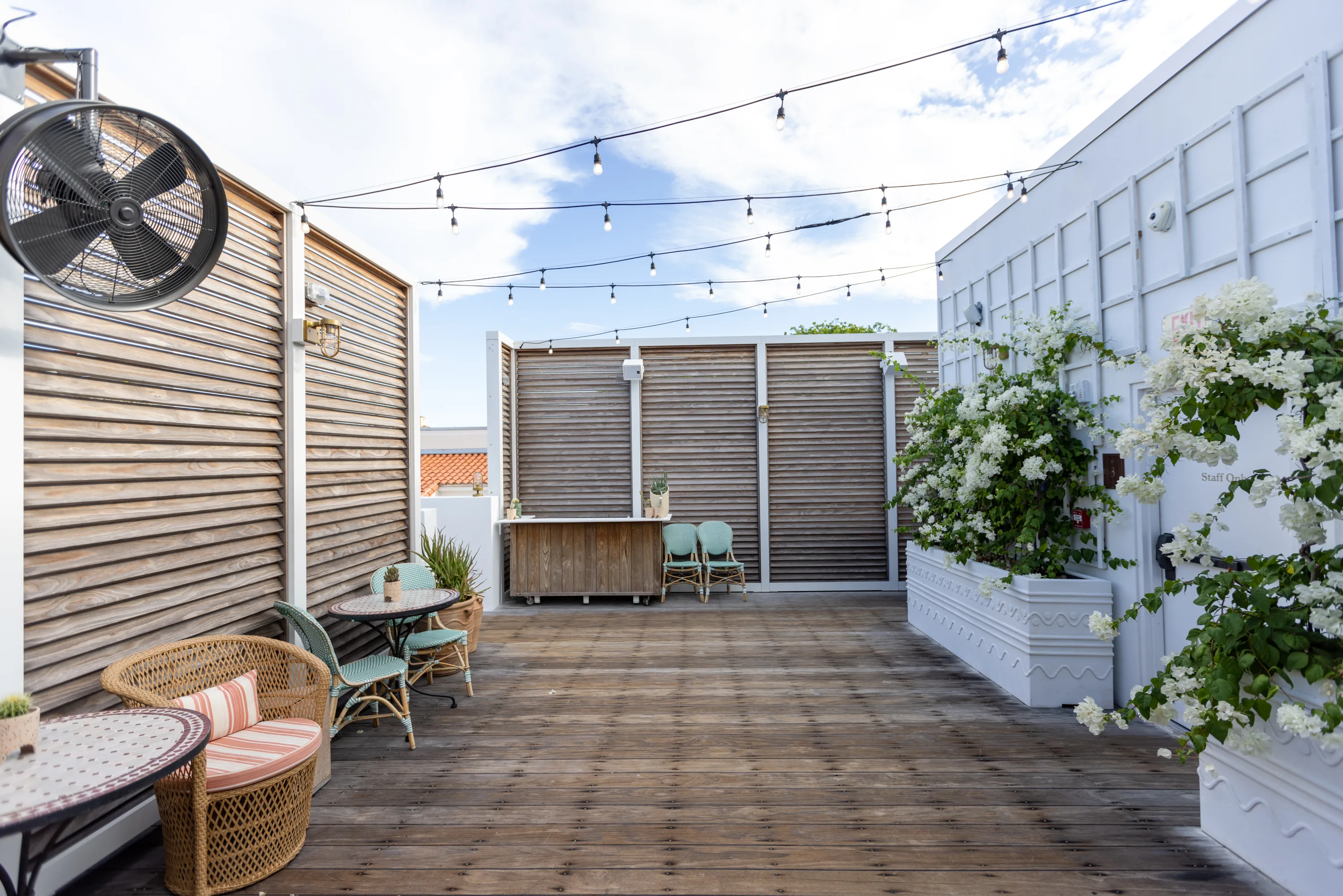 Rooftop deck with wood slat screens, string lights, and bar - Esme Hotel, Miami Beach FL