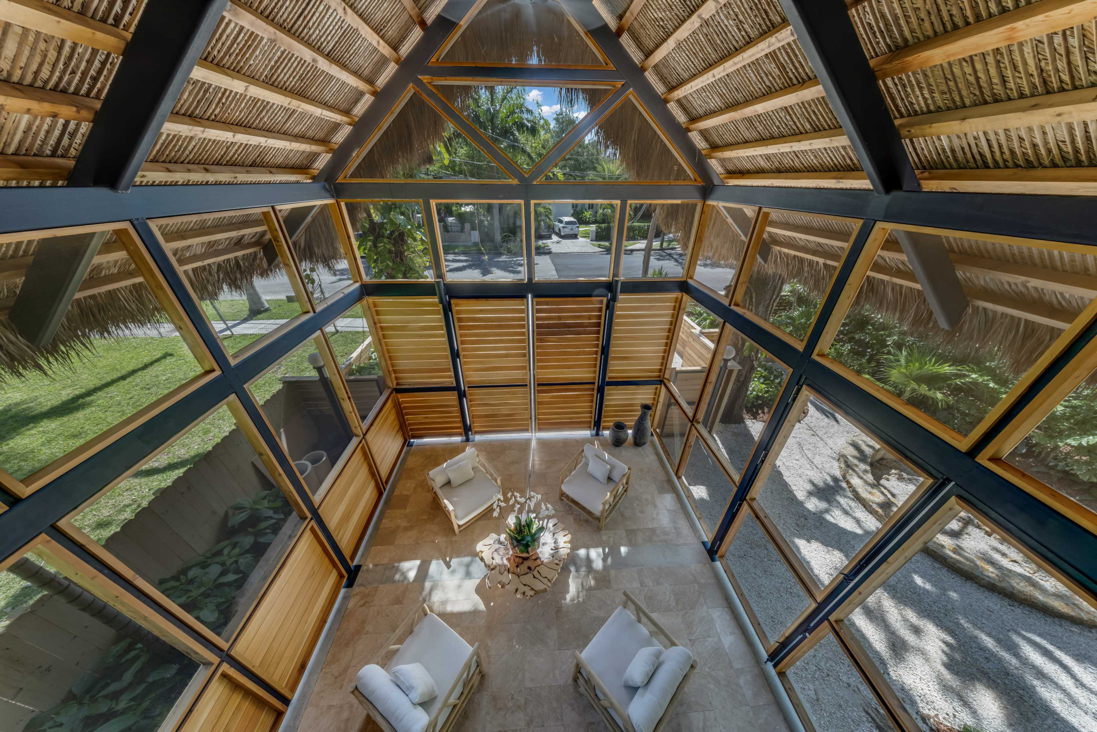 Aerial view of carport interior with steel frame, thatch roof, and cedar louvers - Jungle Book Residence, Miami FL