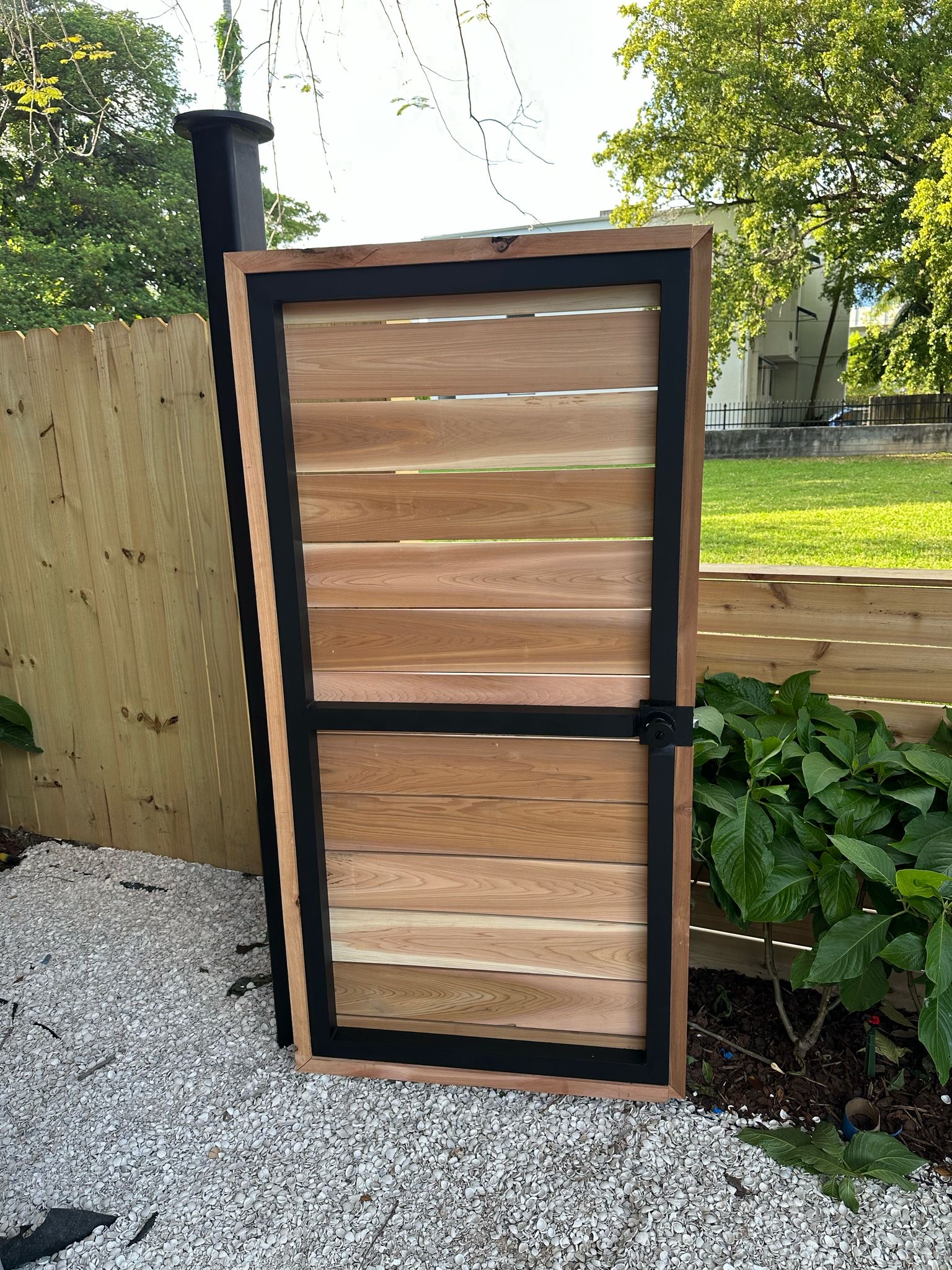 Cedar wood louver gate with black steel frame — Jungle Book Residence, Miami FL