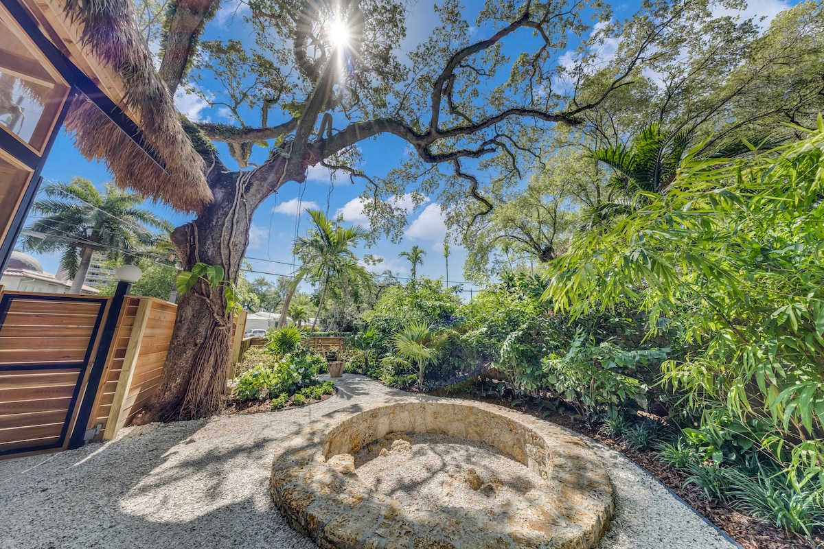 Garden courtyard with cedar wood fence and steel carport structure — Jungle Book Residence, Miami FL