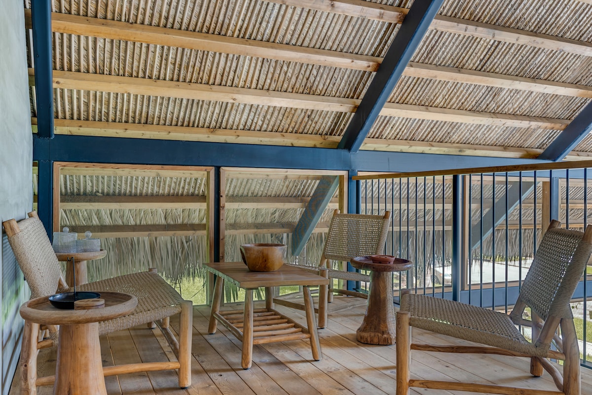 Carport interior with steel beam ceiling, metal railing, and wood deck — Jungle Book Residence, Miami FL