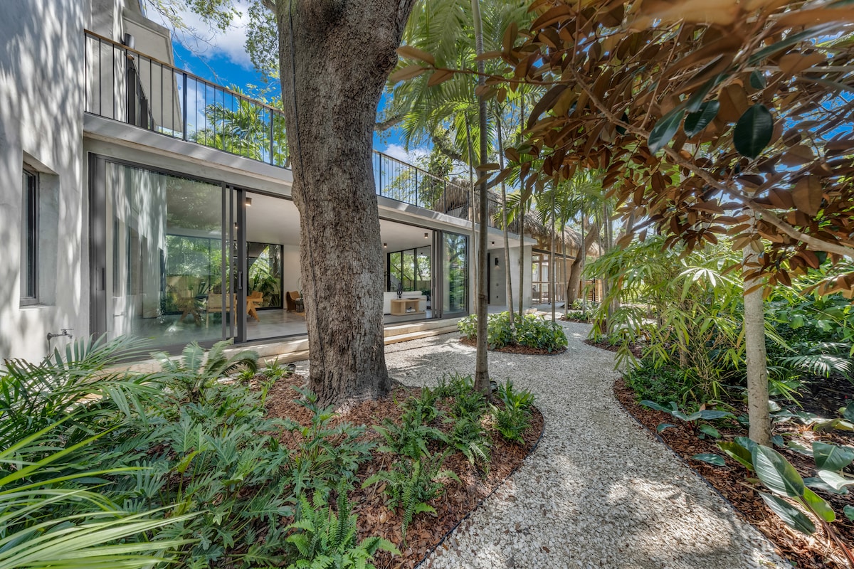 Exterior with metal balcony railings and tropical landscaping — Jungle Book Residence, Miami FL