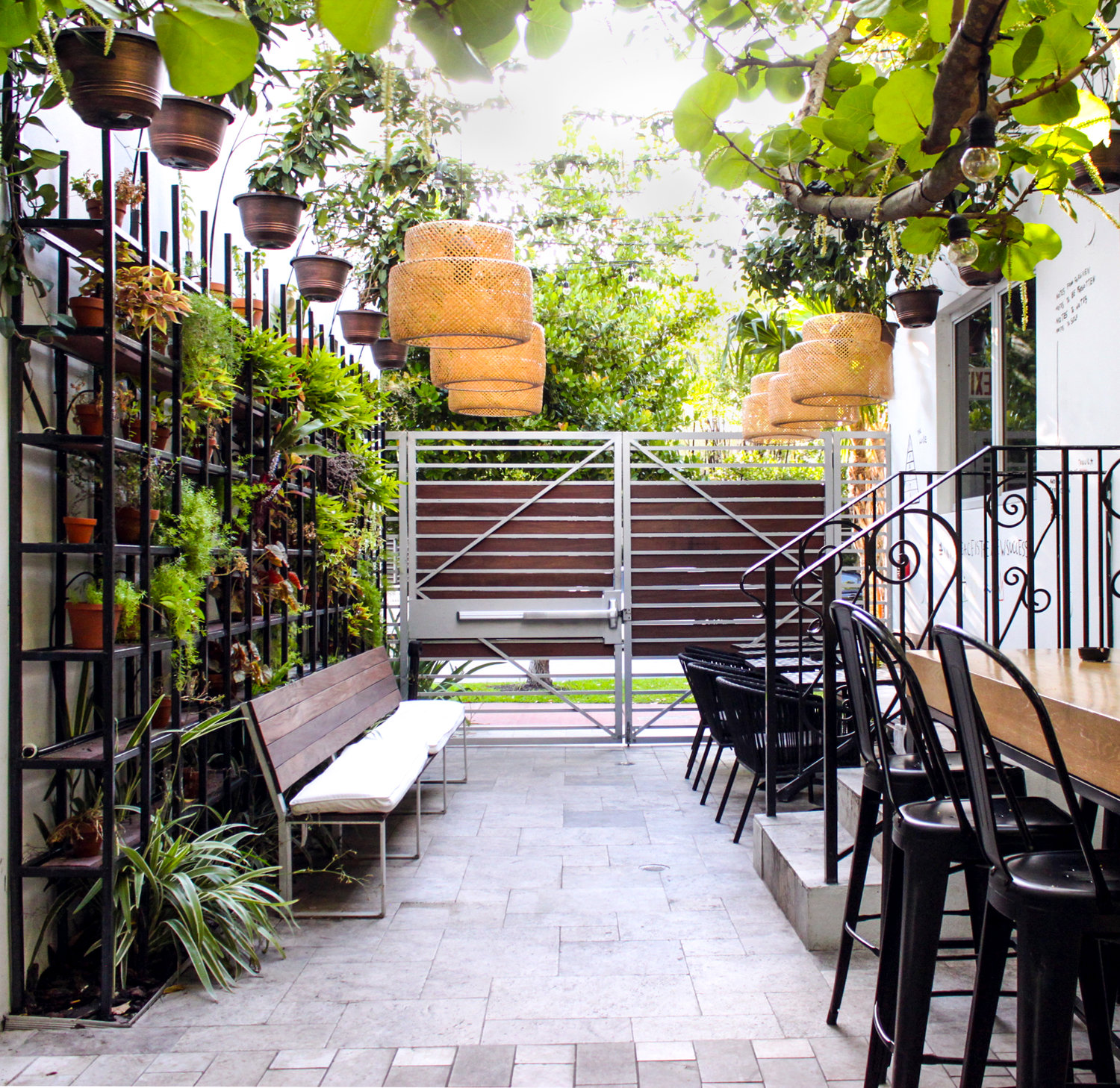Outdoor seating area with metal gate and potted plants at The Meridian Hotel.