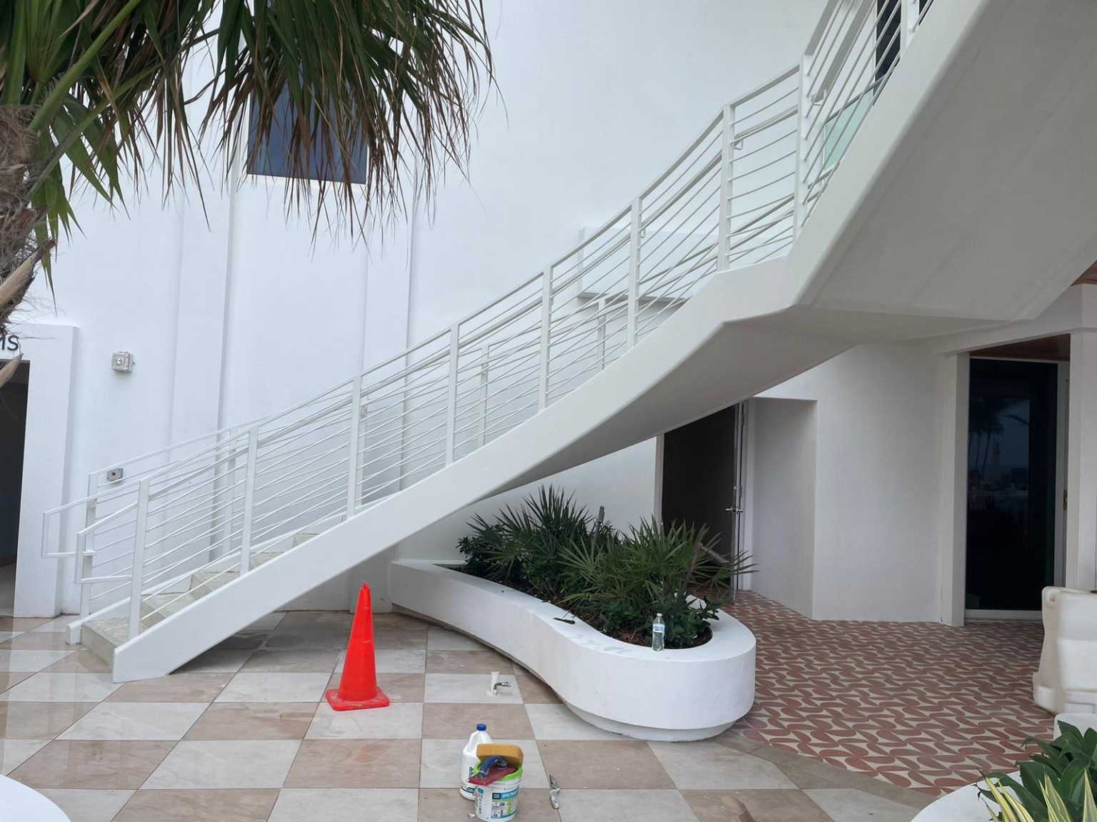 New white curved stair installation with planter